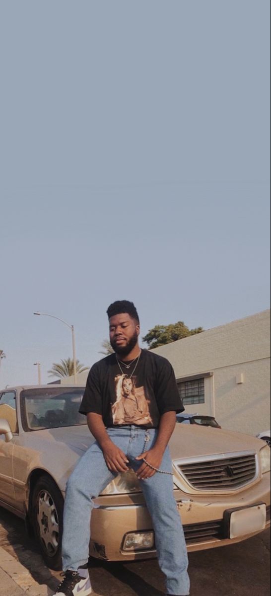 a man sitting on the hood of a car