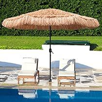 two lawn chairs under an umbrella next to a swimming pool