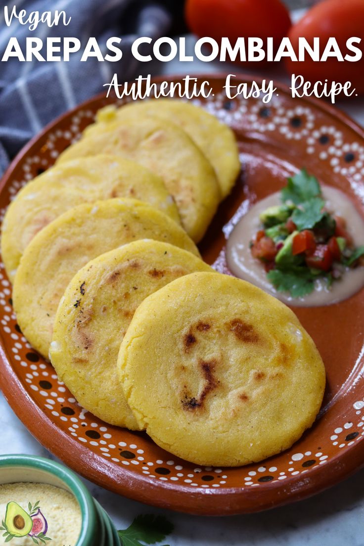 three tortillas on a plate with dipping sauces and tomatoes in the background