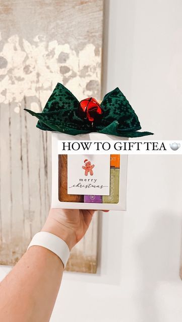 a person holding up a gift box with the words how to gift tea on it