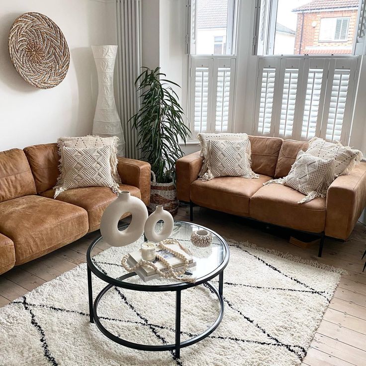 a living room with two couches and a coffee table in front of a window