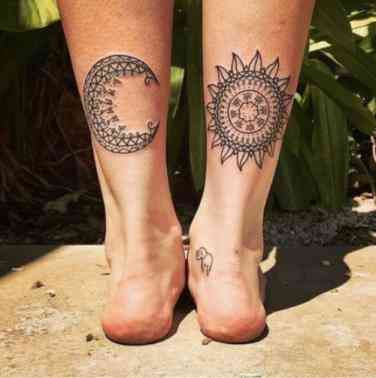 two sun and moon tattoos on both legs, one with an elephant in the middle