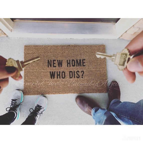 two people holding keys to a door mat that says new home who dis?