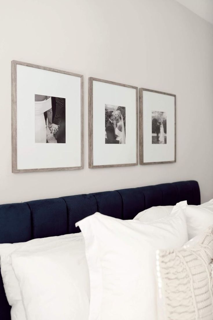 three framed pictures hang on the wall above a bed with white linens and pillows