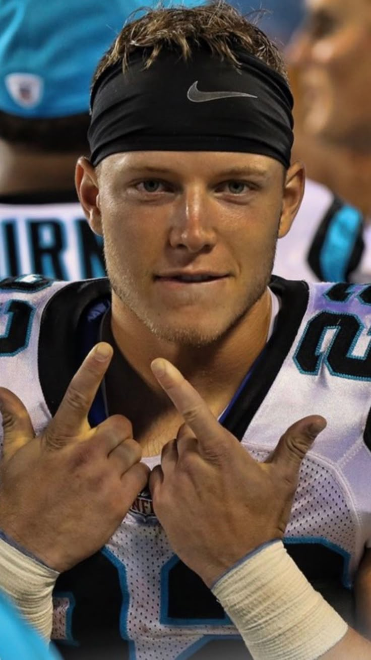 a close up of a person wearing a headband and making the peace sign with his hands