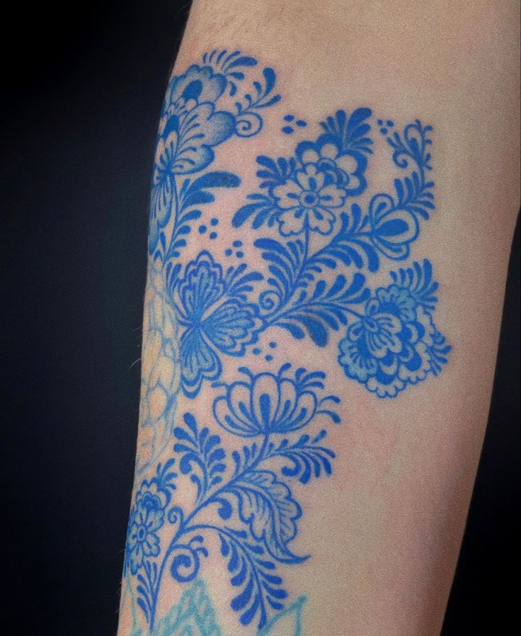 a close up of a person's arm with blue flowers on it