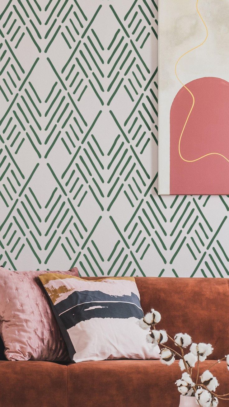 a brown couch sitting next to a painting on top of a wooden table in front of a wall