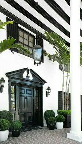 a black and white house with potted plants