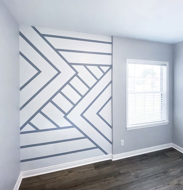 an empty room with wood flooring and painted lines on the wall, along with a window