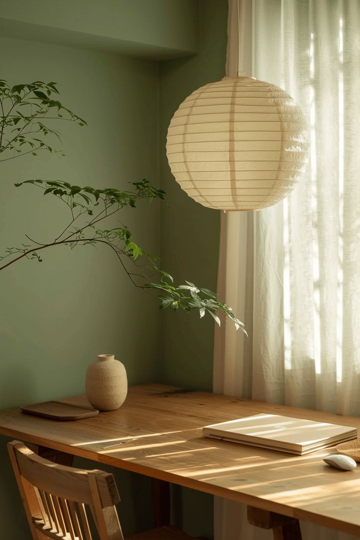 a wooden table topped with a laptop computer next to a plant