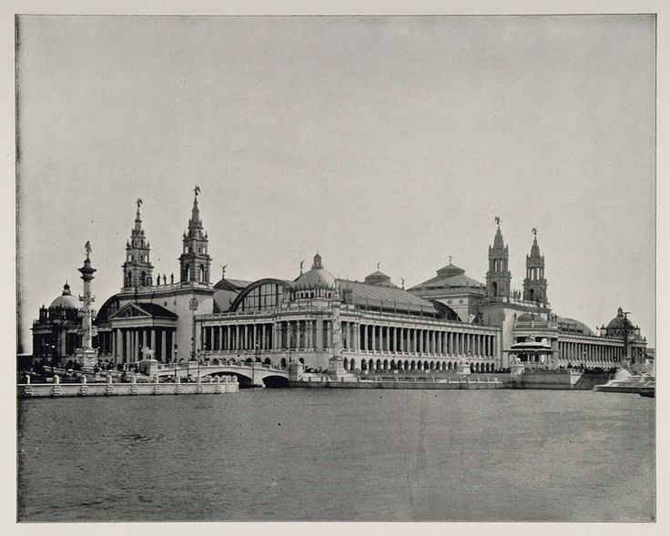 an old black and white photo of a large building on the water's edge