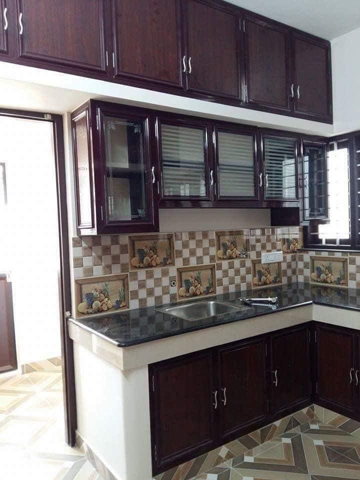 an empty kitchen with wooden cabinets and tile flooring in the middle, along with tiled floors