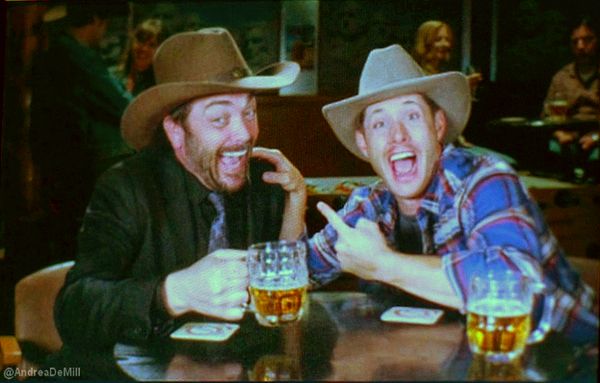 two men sitting at a table with beer glasses