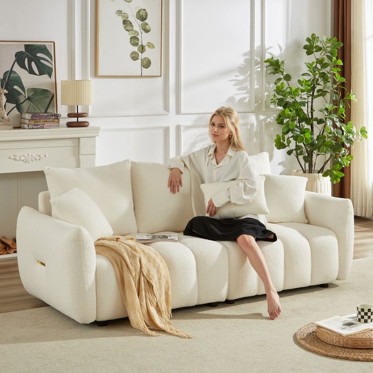 a woman sitting on top of a white couch