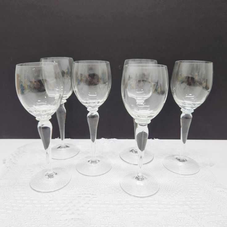 four empty wine glasses sitting on top of a table