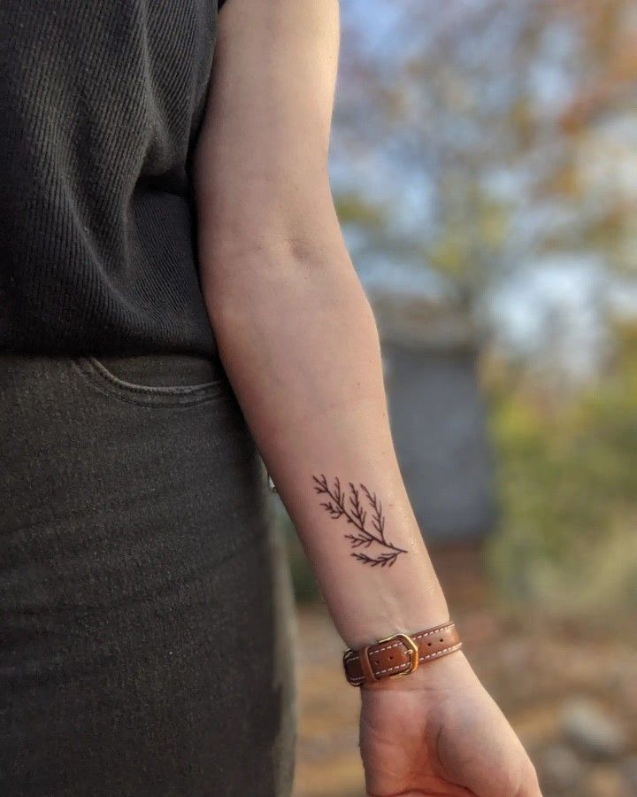 a woman's arm with a small tattoo on it