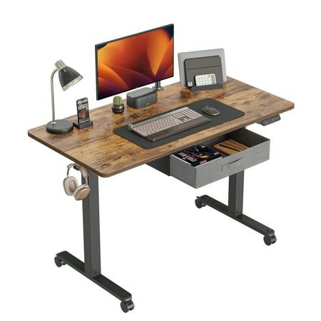 a computer desk with a monitor, keyboard and headphones on top of the desk