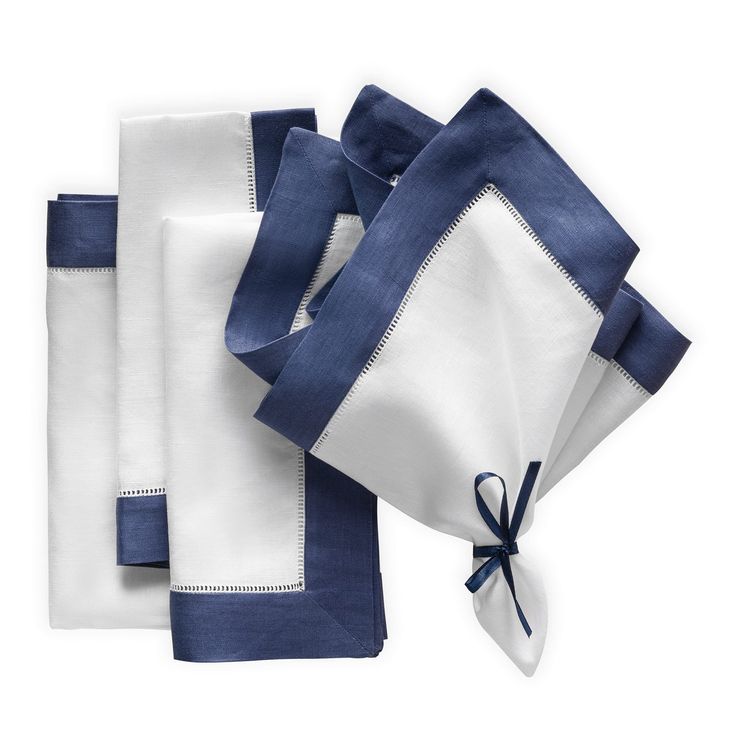 three napkins with blue and white trim on them