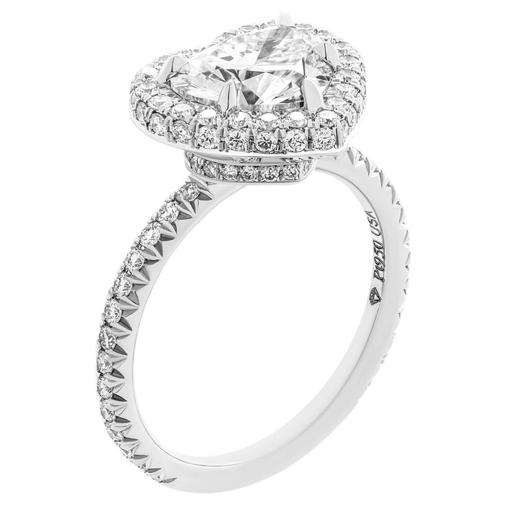 an engagement ring with a heart shaped center surrounded by diamonds