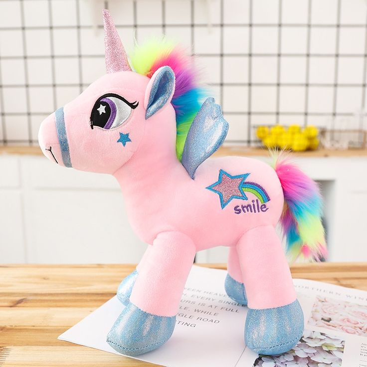 a pink pony stuffed animal sitting on top of a table