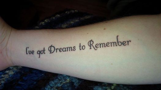 a person with a tattoo on their arm saying i've got dreams to remember