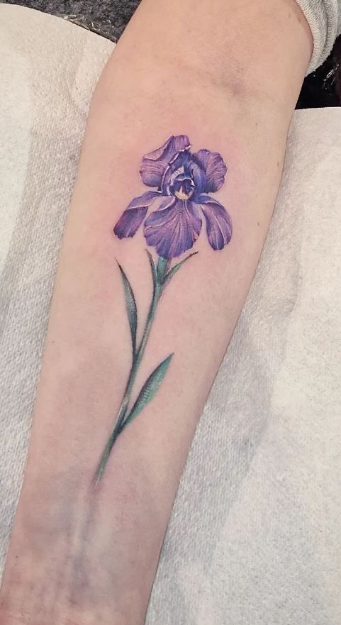 a purple flower tattoo on the arm