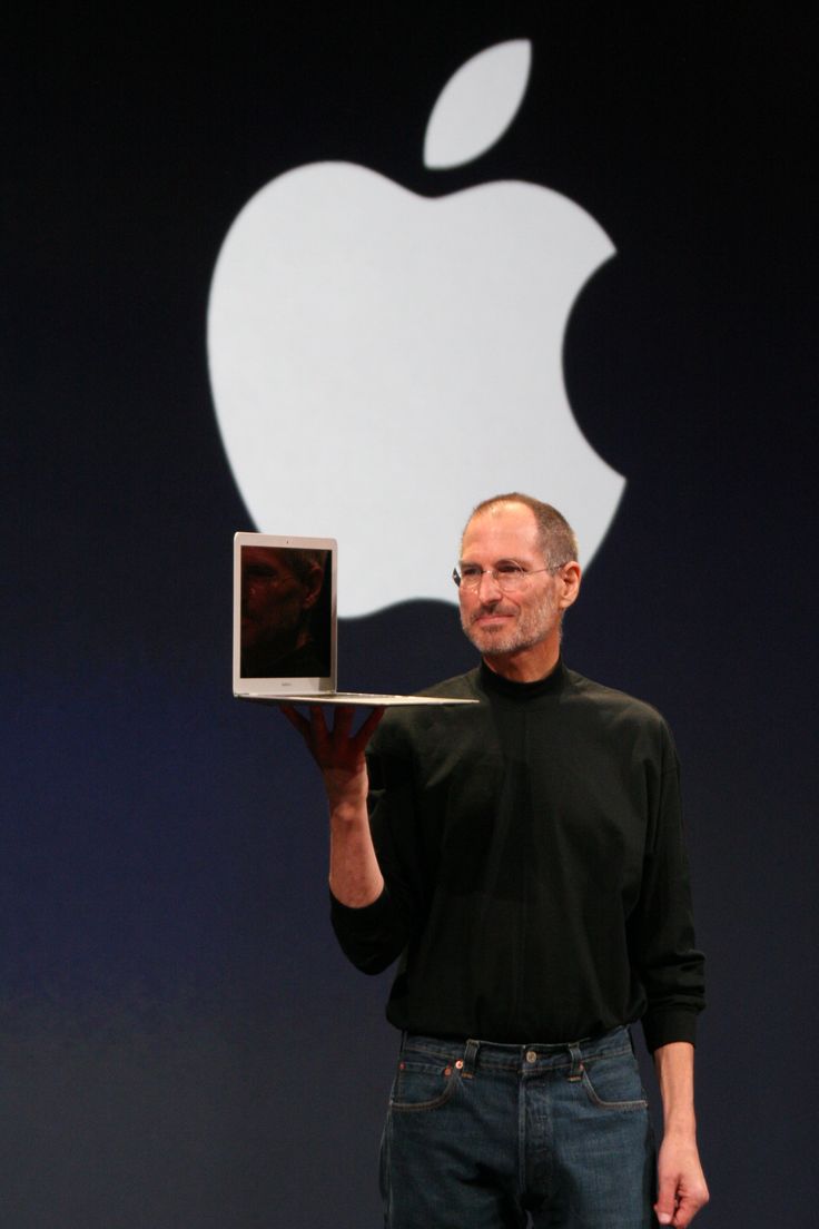 steve jobs holding up an apple computer