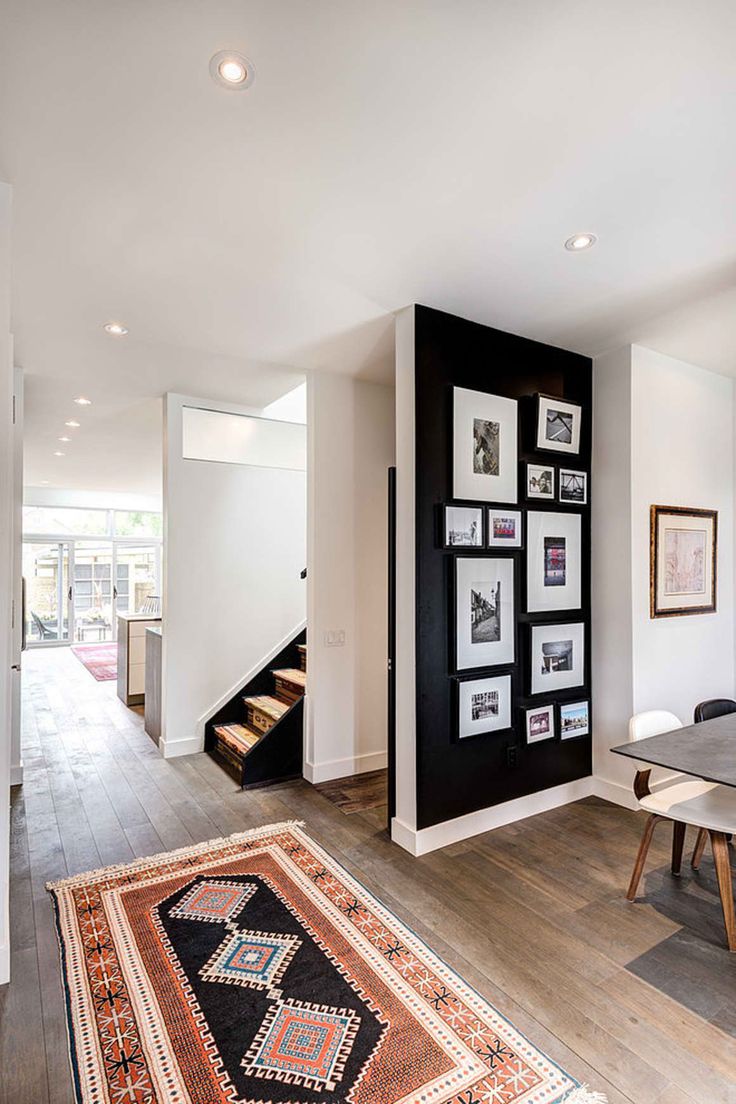 a living room with pictures on the wall and an area rug in front of it