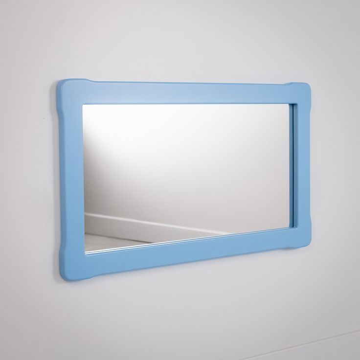 a blue mirror mounted to the side of a wall