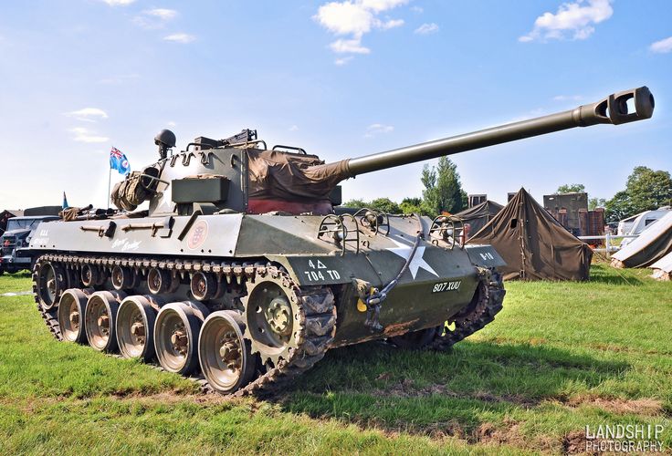 an old tank sitting on top of a lush green field