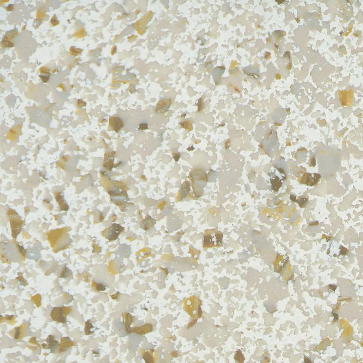 a white and brown speckled surface with small rocks on the bottom left side, and yellow dots on the top right hand corner