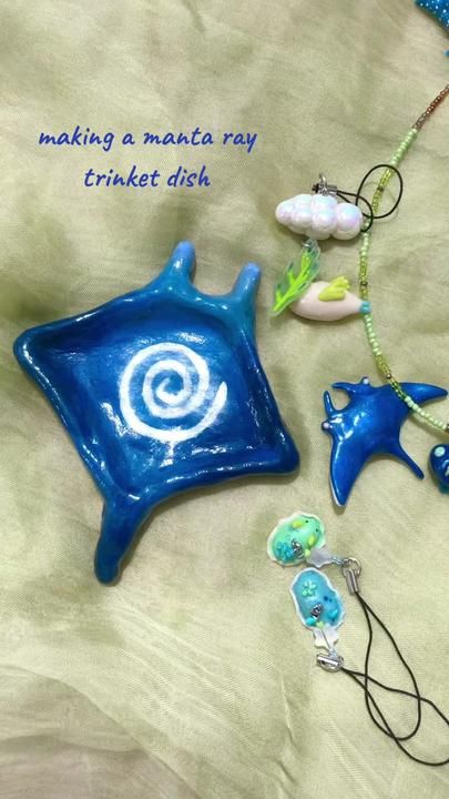 a blue ceramic dish sitting on top of a table next to other decorations and beads