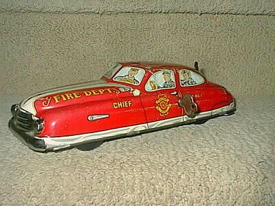 a toy fire department car sitting on top of a carpeted floor next to a wall