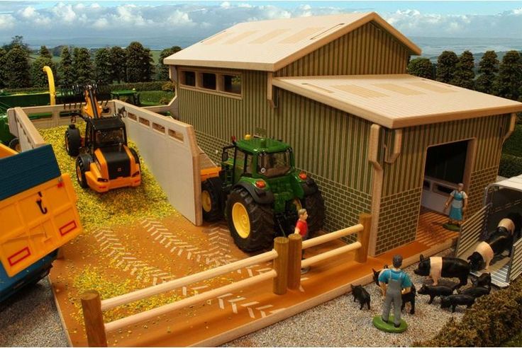 a model farm scene with tractors and people in front of a barn, hay bales and tractor