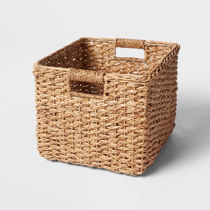 a wicker basket with a handle on the side and a white label in the middle