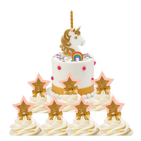 a white cake with gold stars and a unicorn on top is surrounded by cupcakes