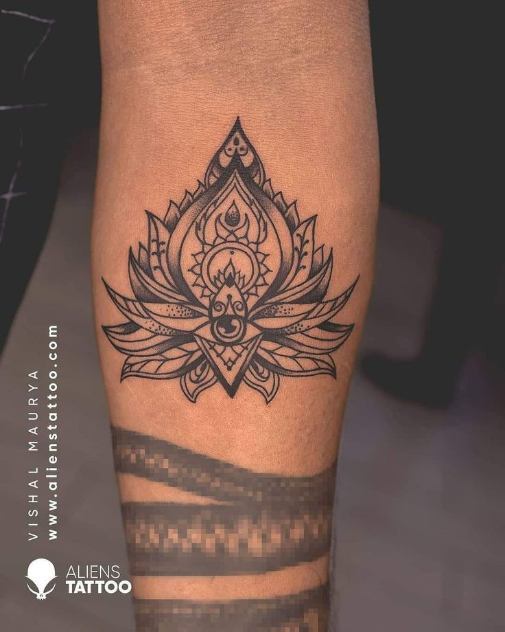 a black and white photo of a tattoo on someone's leg with an ornamental design