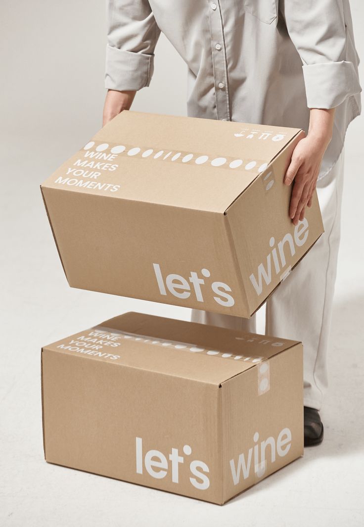 a woman holding two boxes that say let's wine