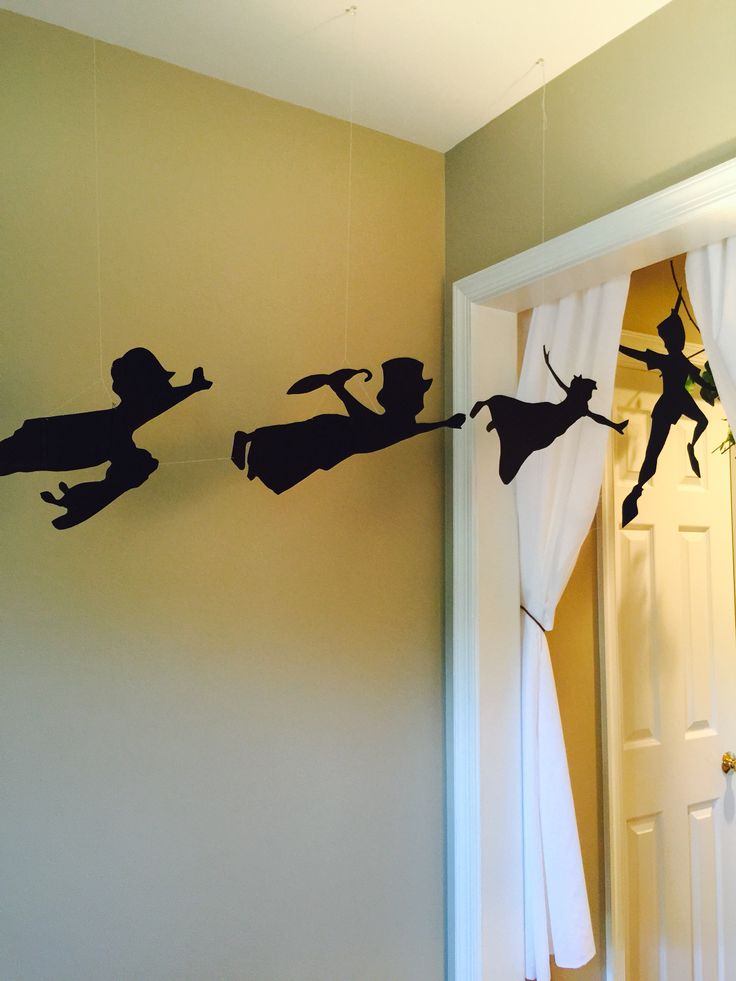 the silhouettes of people are hanging on the wall above the door and behind the curtains