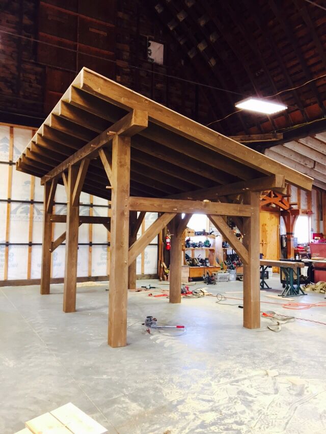 the inside of a building that is being built with wooden beams and wood planks