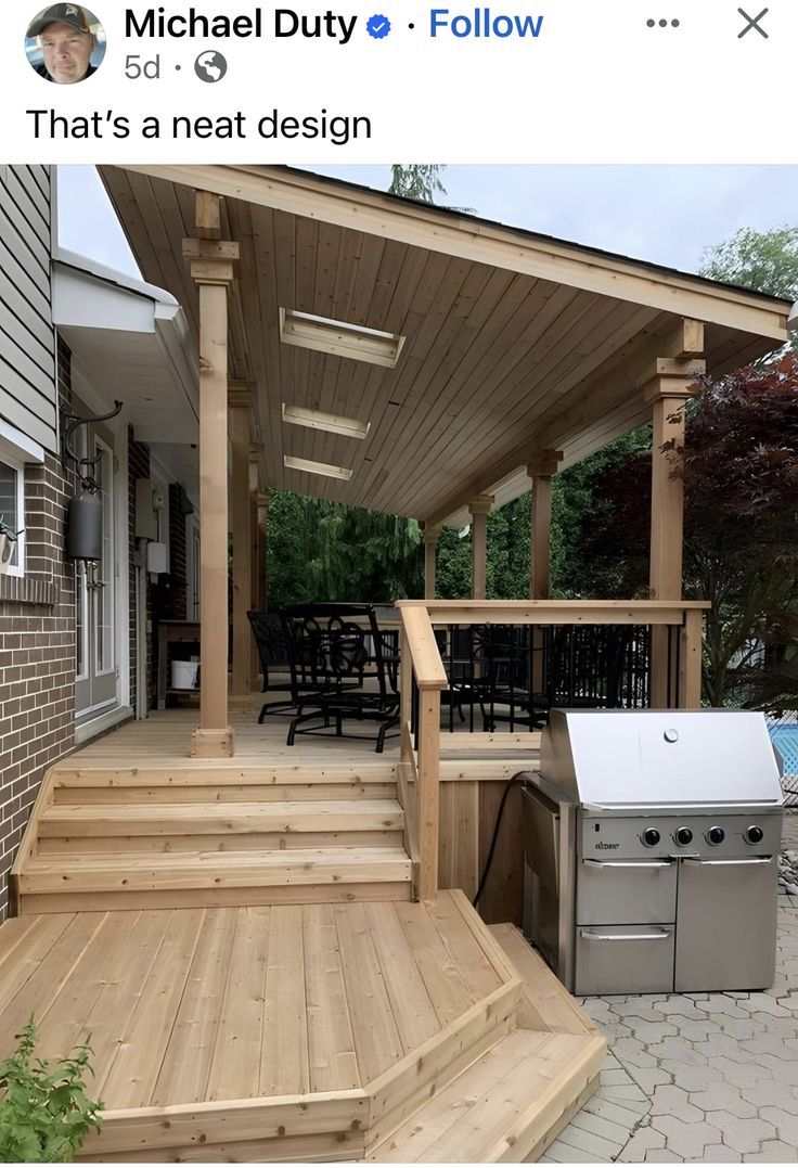 an outdoor kitchen and grill on a deck with stairs leading up to the back door