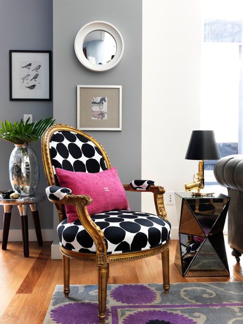 a living room filled with furniture and pictures on the wall next to a chair in front of a window