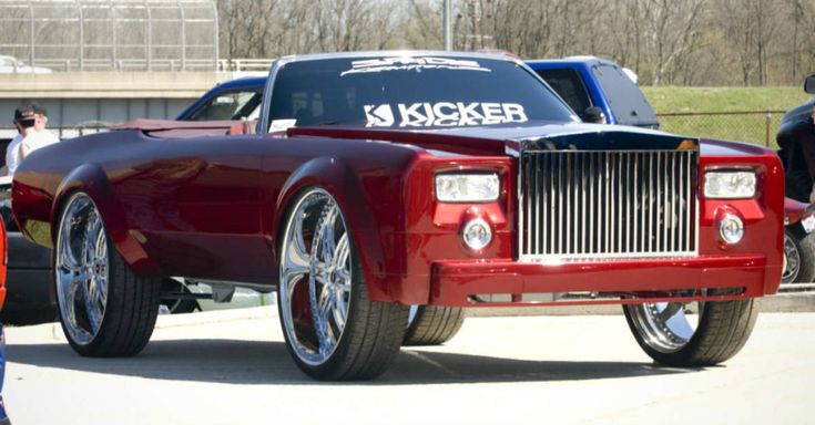 a red pick up truck parked next to other cars