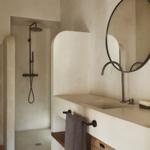 a bathroom with a sink, mirror and towel rack in the middle of the room