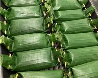 several pieces of green leafy food sitting on top of a metal tray next to each other