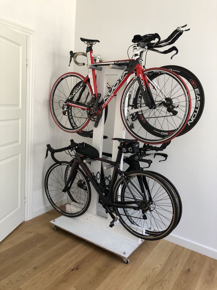 two bikes are mounted to the wall on a bike rack in front of a door