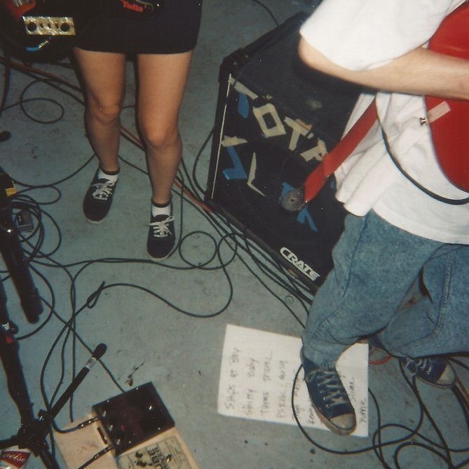 two people standing next to each other in front of microphones and music equipment on the floor