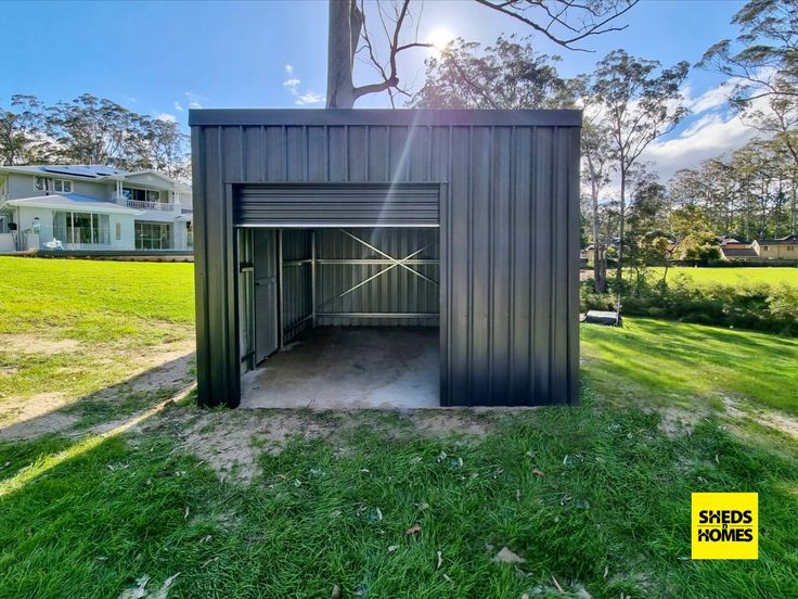 an open garage in the middle of a grassy field