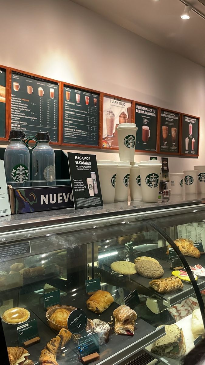 there are many different types of pastries on display in the case at this coffee shop