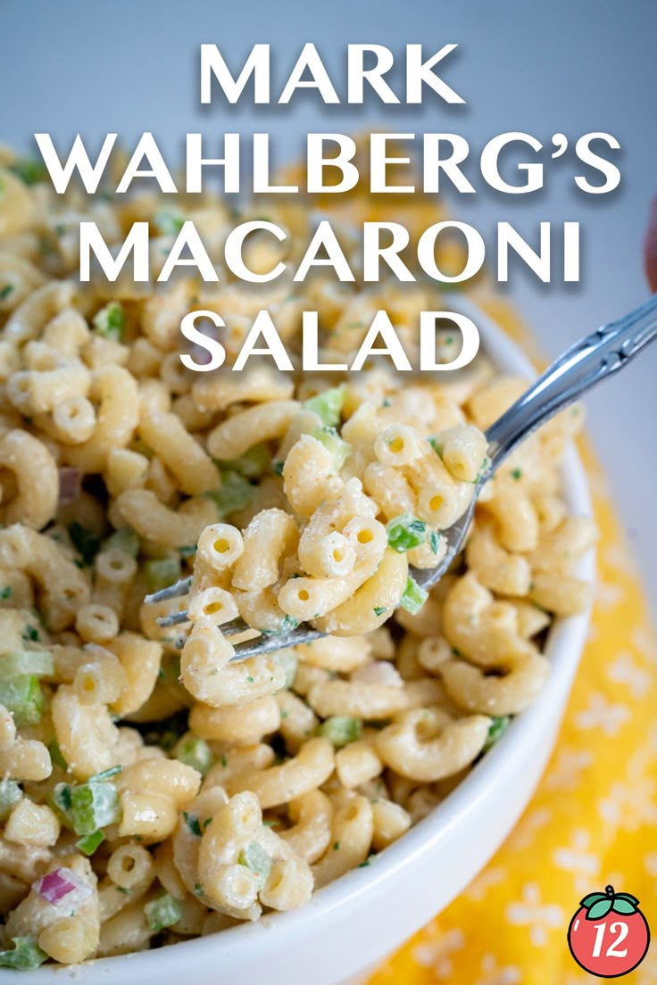 a white bowl filled with macaroni salad on top of a yellow table cloth